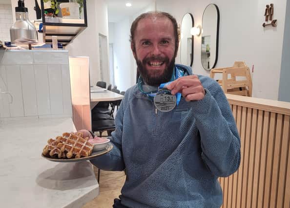 A Beachy Head Half Marathon runner with their free waffle from the Company Restaurant, Eastbourne SUS-211021-143136001