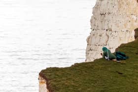 A person was seen looking over the edge of Beachy Head as they took a picture at the cliffs. (Picture from Tyrone Campbell/SWNS) SUS-211027-130746001