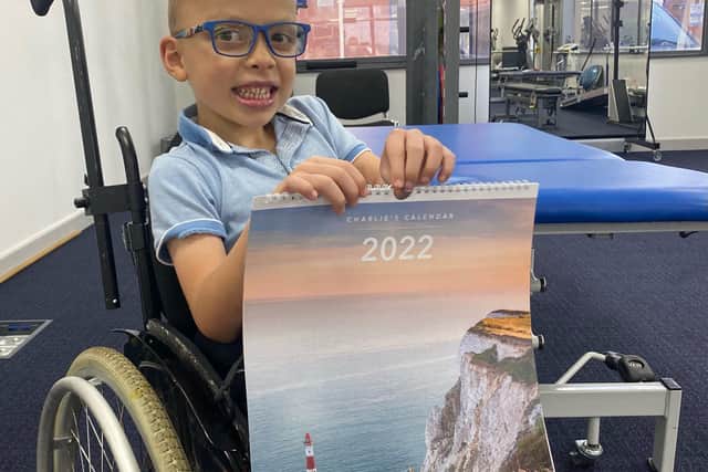Charlie Fielding with his dad's 2022 calendar at the gym he uses thanks to funds raised through sales