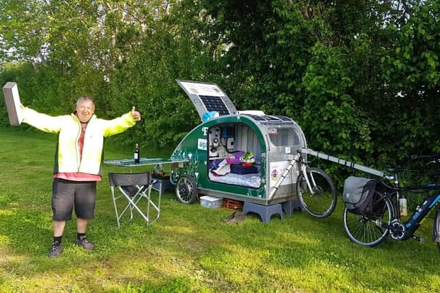 Simon Aylett with his bike and homemade miniature caravan SUS-211031-112422001