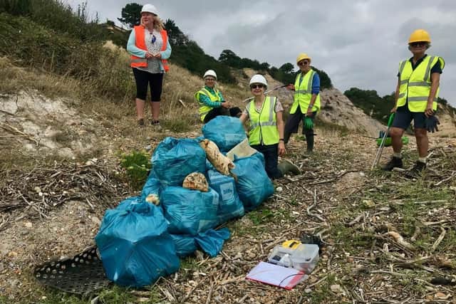 Strandliners bagging up rubbish at Fairlight Cove SUS-210411-075821001