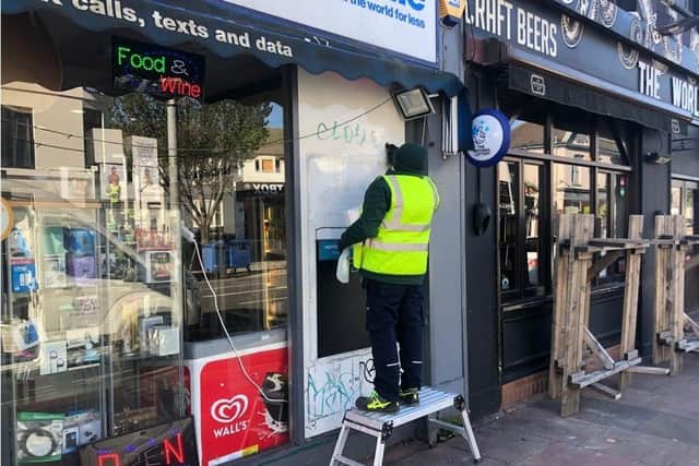 One of the graffiti cleaning team gets to work on a shop in London Road on Wednesday this week.