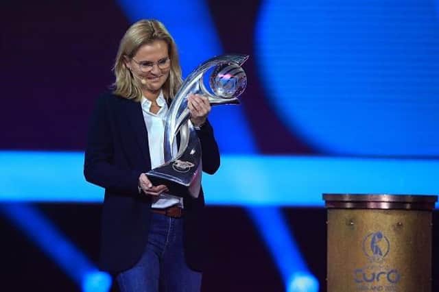 England's women's football manager Sarina Wiegman carries the trophy ahead of the draw for the UEFA Women's EURO 2022 final tournament