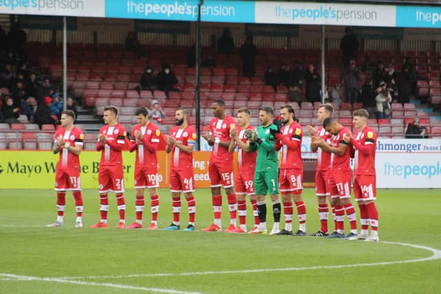 The players and staff of Crawley Town and Mansfield Town joined together with the fans for a minutes applause prior to the match, in memory of Dermot Drummy. Yems’ side wore black armbands. Photo: Cory Pickford