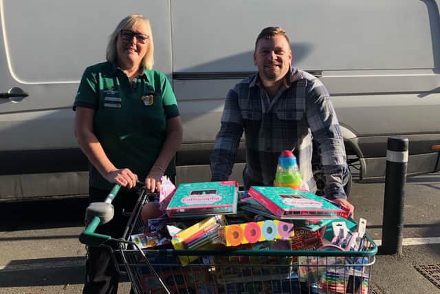 Alison Whitburn, community champion, and V2 Radio DJ Gary Booker with one of the trolleys of toys donated by customers at Morrisons Littlehampton for the V2 Radio Christmas Toy Appeal