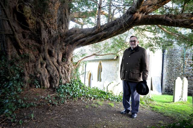 Father Peter Mallinson in Coldwaltham churchyard with the tree is thought to be 3,000 years old and is among the oldest trees in England. Pic S Robards SR2112014 SUS-210112-170319001