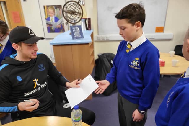 Sussex bowler Jamie Atkins signs an autograph