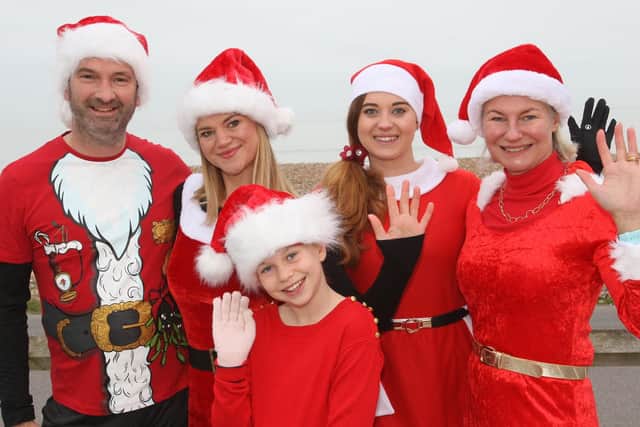 DM21120424a.jpg. Santas on the Seafront. Family members from left, Simon Ball, Emma Ball, Bella Hobson 9, Melissa Day and Vanessa Maile. Photo by Derek Martin Photography and Art. SUS-211112-182952008
