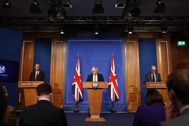 British prime Minister Boris Johnson, Britain's Chief Medical Officer for England Chris Whitty and Chief Scientific Adviser Patrick Vallance hold a press conference at 10 Downing Street on December 8 (Photo by Adrian Dennis-WPA Pool/Getty Images)