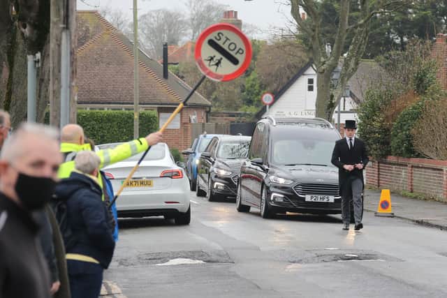 Scores of people lined the street to pay tribute to Worthing lollipop man Terry Rickards as his funeral cortege drove past the spot where he served