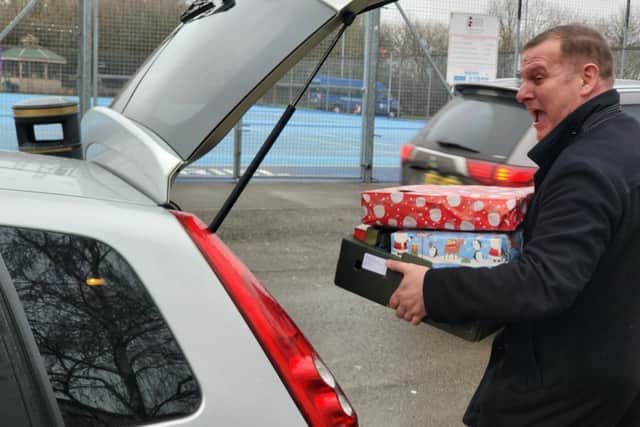 Darren Greenaway loads up a car with presents and food
