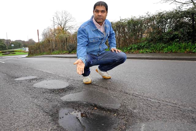 Mustak Miah points out a pothole near the roundabout on Royal George Road, Burgess Hill. Picture: Steve Robards, SR2201112.