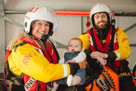 RNLI Brighton volunteer Emily Summerfield with fellow crew member Julian Cumberworth, who was the anaesthetist when baby William, also pictured, was born