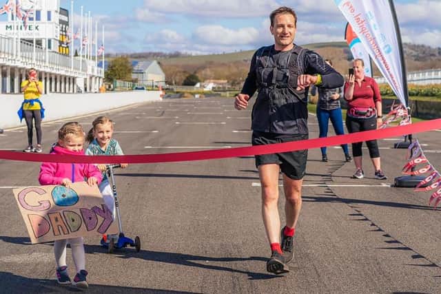 Seth completing his 26.2 mile marathon run around the Goodwood Motor Circuit in April 2021 as part of his training and fundraising, and was greeted by his two of his three daughters, Primrose and Lettie b8IUQO5bqN37DyH_RuQj