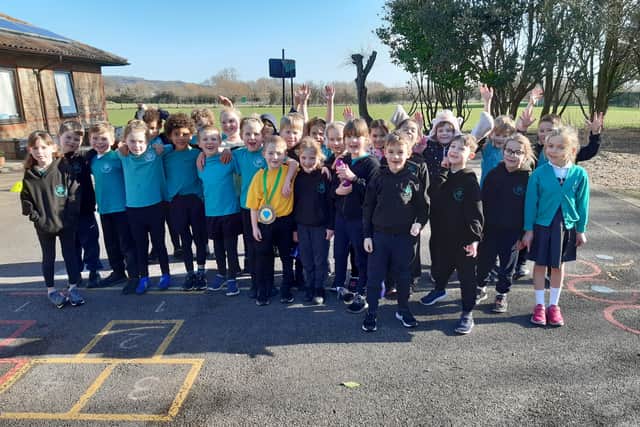 Benji Higgins, wearing a medal made for him by the children at Chestnut Tree House, with his year-two class at Bramber Primary School in Worthing