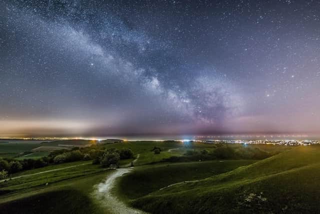 The milkyway above the lights of Worthing and Brighton from Cissbury Ring with the lights of the Rampion Wind farm in the background by Neil Jones SUS-221102-092840001