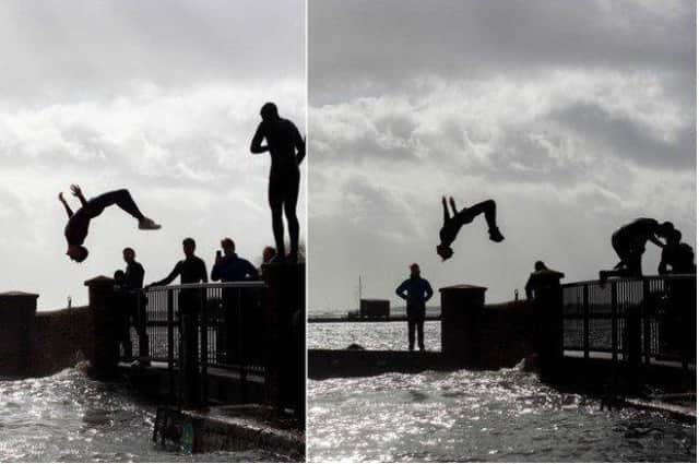Thrill-seekers pictured backflipping into Emsworth Harbour as Storm Eunice rages. Photo: Habibur Rahman SUS-220218-184517003