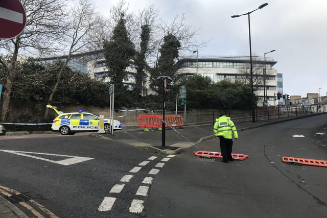 Police close off an area of Hastings town centre after scaffolding boards fall off building SUS-220218-150146001