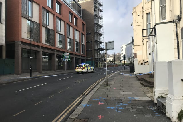 Police close off an area of Hastings town centre after scaffolding boards fall off building SUS-220218-150101001