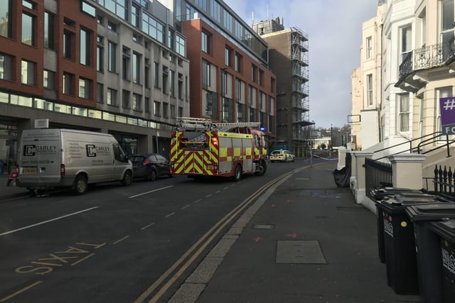 Police close off an area of Hastings town centre after scaffolding boards fall off building SUS-220218-150112001