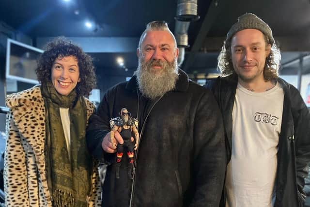 Stu Allen, aka The Dominator (centre) with the action figure that resembles him SUS-220221-114704001