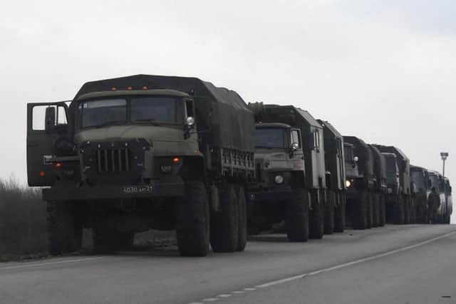 Russian military trucks and buses are seen on the side of a road in Russia's southern Rostov region, which borders the self-proclaimed Donetsk People's Republic, on February 23, 2022. 
(Photo by STRINGER/AFP via Getty Images)