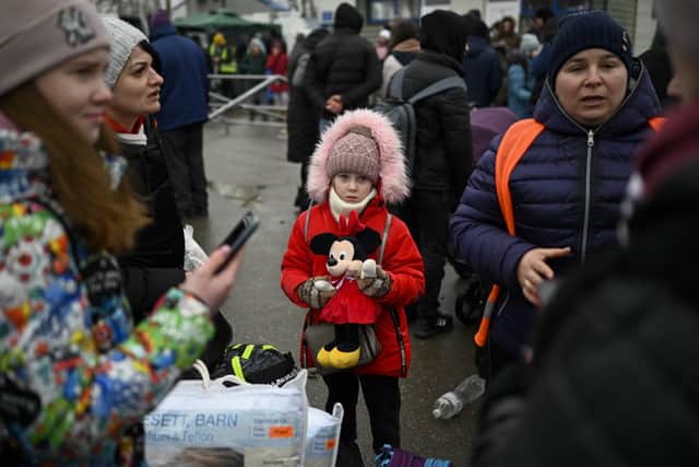 A young refugee girl from Ukraine waits to enter a bus at the Moldova-Ukrainian border's checkpoint near the town of Palanca on March 1, 2022. (Photo by Nikolay DOYCHINOV / AFP) (Photo by NIKOLAY DOYCHINOV/AFP via Getty Images)