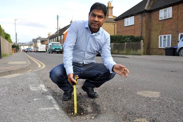 Mustak Miah at the dangerous deep potholes in Royal George Road, Burgess Hill. Picture: Steve Robards, SR2203011.