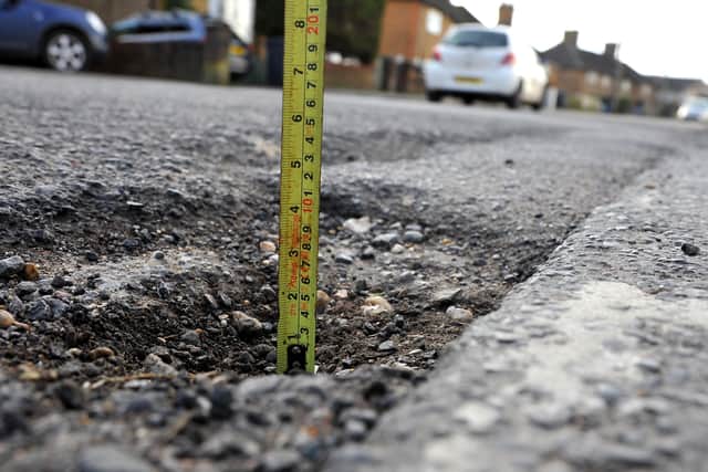 Dangerous deep potholes in Royal George Road, Burgess Hill. Pictured: Steve Robards, SR2203011.