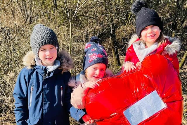 German siblings Anna, Georg, and Sophia pictured with the red heart-shaped balloon sent from Worthing.