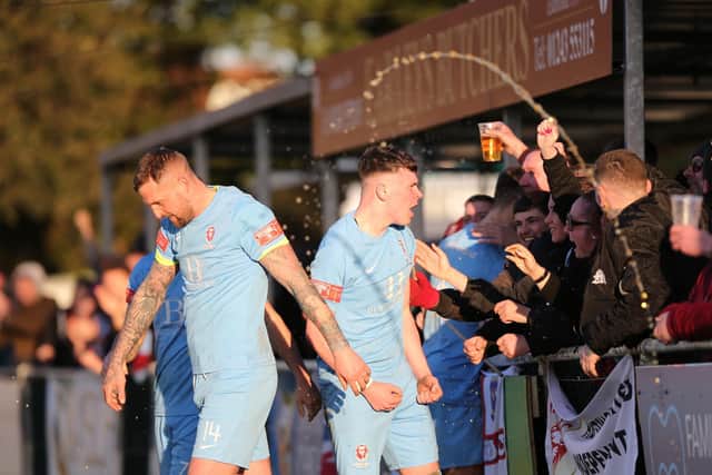 The beer goes flying as fans celebrate James Hull's match-clinching goal at Chichester / Picture: Scott White