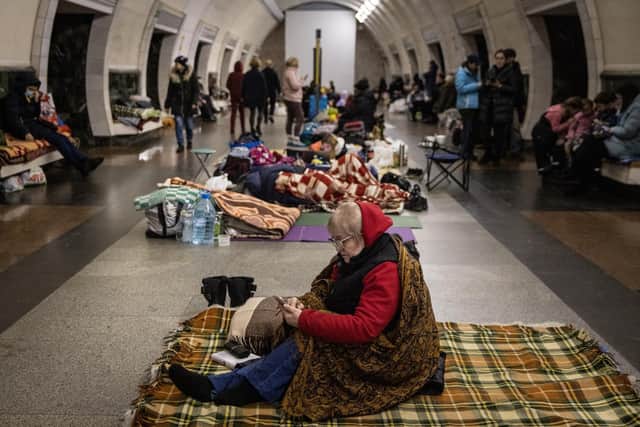 A woman uses her mobile phone as she takes shelter in the Dorohozhychi subway station which has been turned into a bomb shelter on March 02, 2022 in Kyiv, Ukraine. Russian forces continued their advance on the Ukrainian capital for the seventh day as the country's invasion of its western neighbor goes on. Intense battles are also being waged over Ukraine's other major