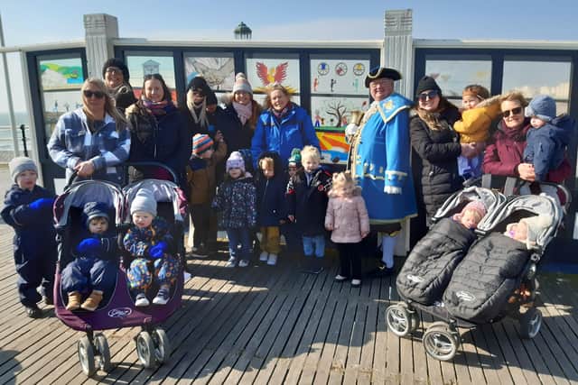 Worthing town crier Bob Smytherman joins Magic Minders on Worthing Pier to view the new glass window for the group's 20th anniversary