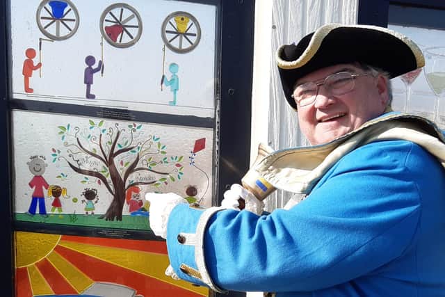 Worthing town crier Bob Smytherman with the Magic Minders glass window