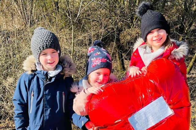German siblings Anna, Georg, and Sophia pictured with the red heart-shaped balloon sent from Worthing.