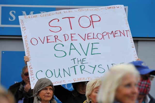 A resident holds up a placard at a recent housing protest in Sussex