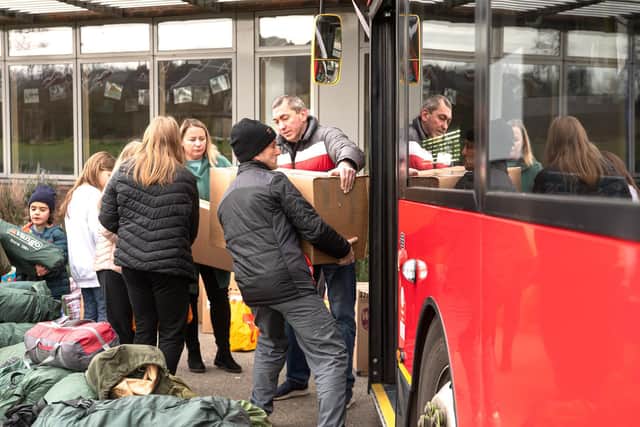 Volunteers help load the buses