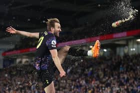 Harry Kane volleys a bottle thrown from the crowd during his goal celebration against Brighton and Hove Albion at the Amex Stadium last night