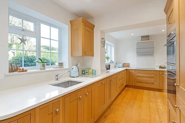 The kitchen has been fitted with Sileston surfaces, a range of wall-hung and under-counter units by Gardiner of England and Smeg appliances. Picture: Savills - Haywards Heath.