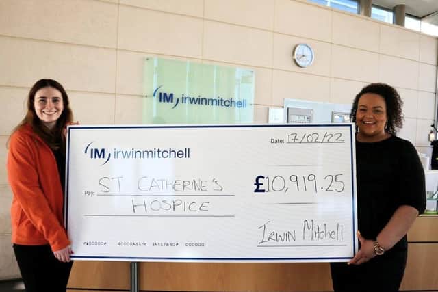 Emma (left) from St. Catherine’s Hospice in Crawley receiving a cheque from Irwin Mitchell's Lacey St James (right) SUS-220321-181539001