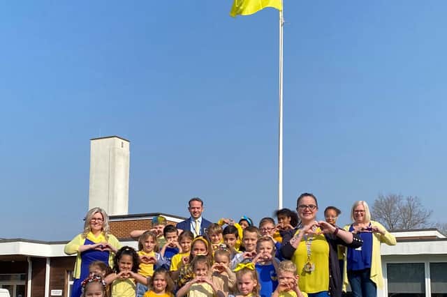 Children and staff beneath the Ukrainian flag.