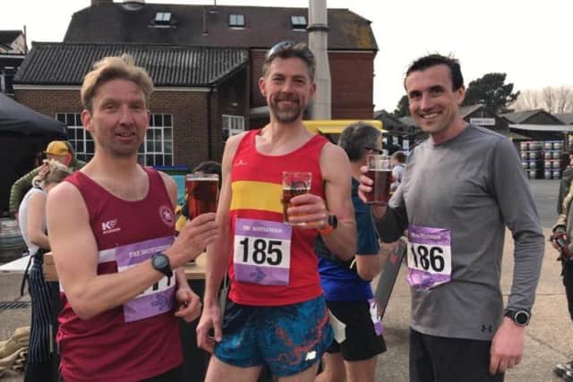 Haywards Heath Harriers either side of a Lewes AC runner at the famous Moyleman Marathon