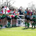 Harlequins come out, accompanied by their Horsham mascots