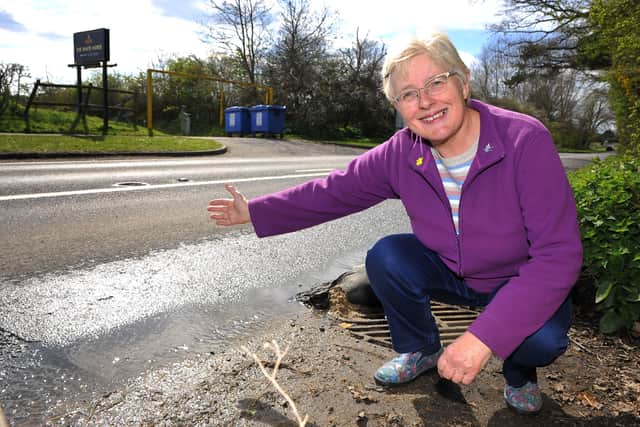 Christine Lindsay who is concerned about a continuous flood in the road, now causing potholes at Pulborough. Pic S Robards SR2204062 SUS-220604-102743001