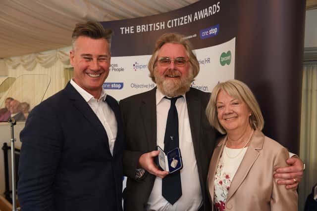 Stephen Page-Mitchell with Dame Mary Perkins and TV host Tim Vincent during the medal ceremony. Mr Page-Mitchell has been a postman for a rural village in Battle for 30 years, and has been celebrated for his contributions to the community. SUS-220804-115321001