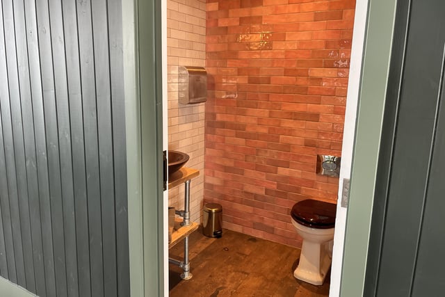 The toilets on the first floor are bright and inviting with a cool tile features