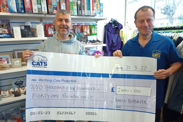 James Baydar presents Worthing Cats Protection treasurer Guy Chadwick with a cheque for £2,441 following his marathon fundraising effort in 2021