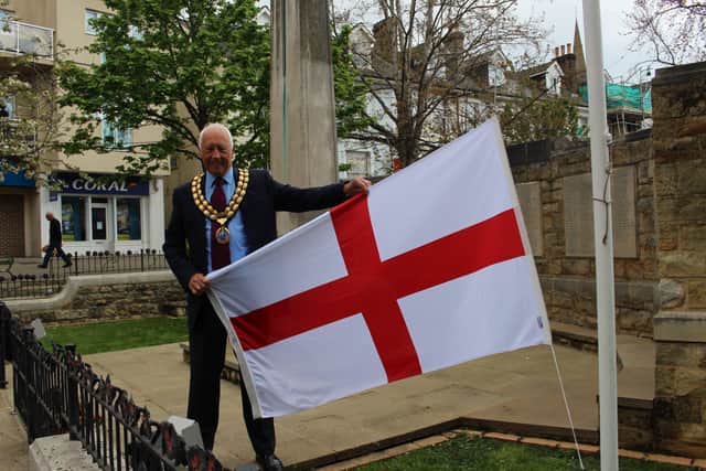 Horsham District Council chairman David Skipp raises the St George's flag