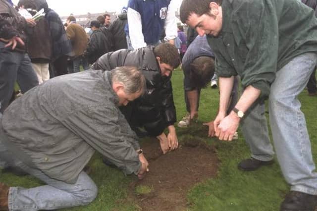 Brighton and Hove Albion fans take home pieces of the pitch after their final match at the Goldstone Ground 25 years ago