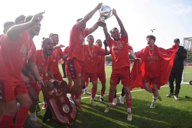 Worthing players get their hands on the trophy / Picture: Marcus Hoare